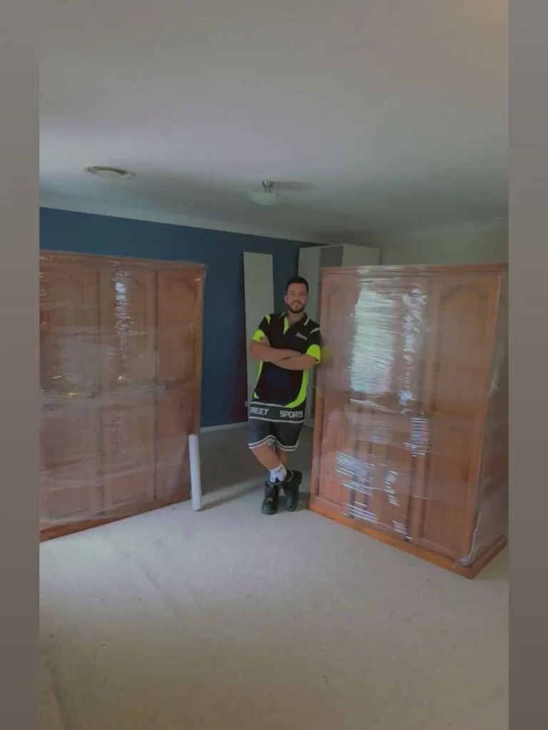 Melbourne to Sydney movers safely lowering an oversized cupboard from a tight balcony